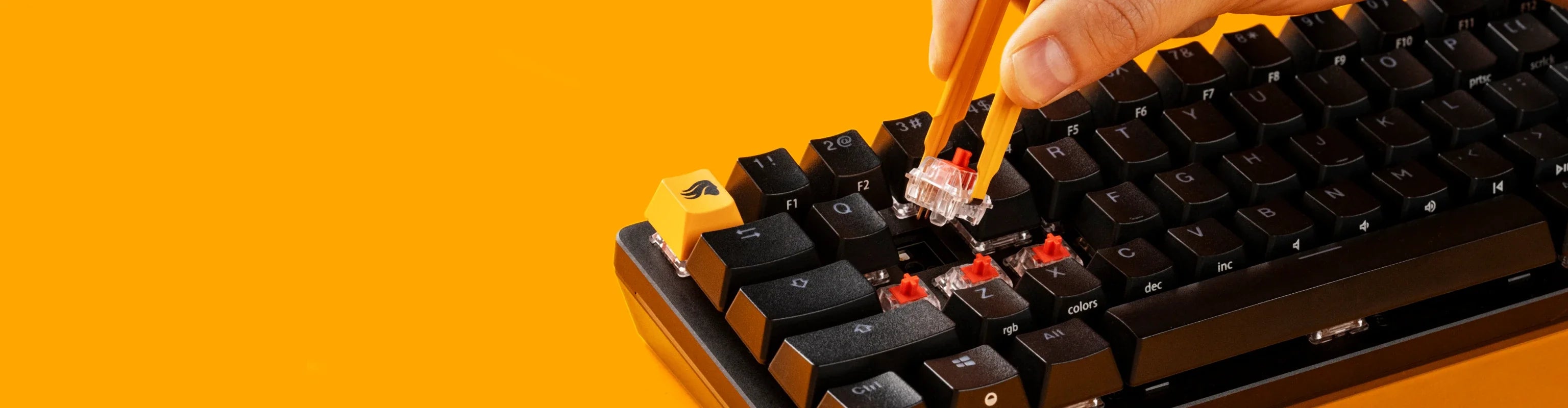 Person replacing switches with a switch puller on a Black GMMK 2 keyboard