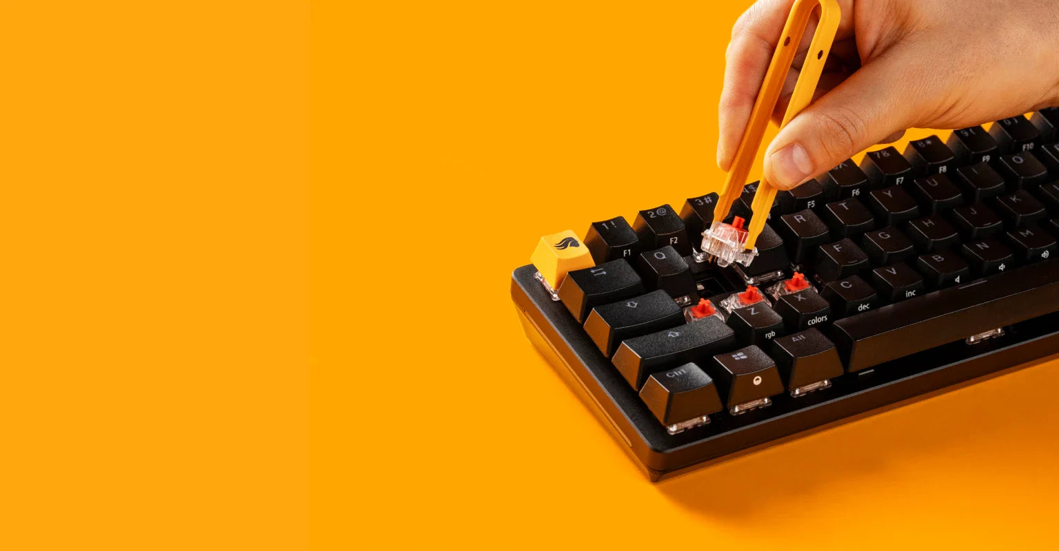 Person replacing switches with a switch puller on a Black GMMK 2 keyboard